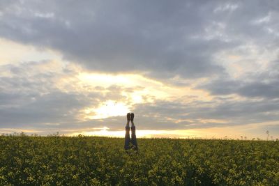 Man standing on field against sky during sunset