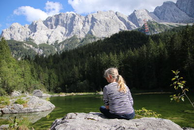 Woman sitting on rock looking at mountains