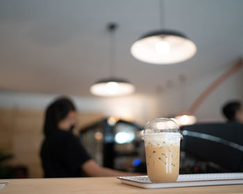 Reflection of woman in glass on table