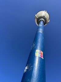 Low angle view of security camera against clear blue sky