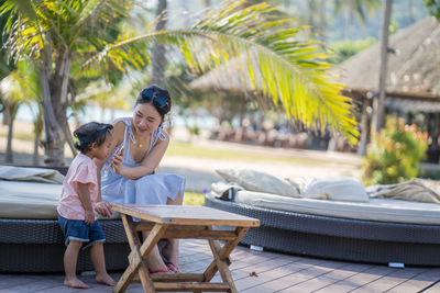 Mother and daughter sitting outdoors