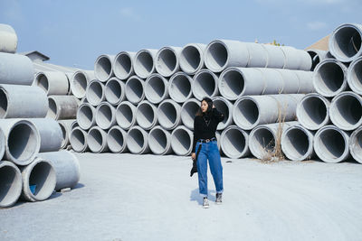 Full length of man standing by stack against sky