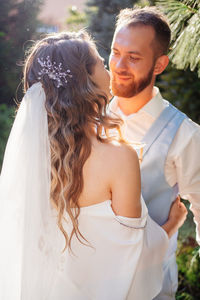 Bridegroom embracing while standing outdoors