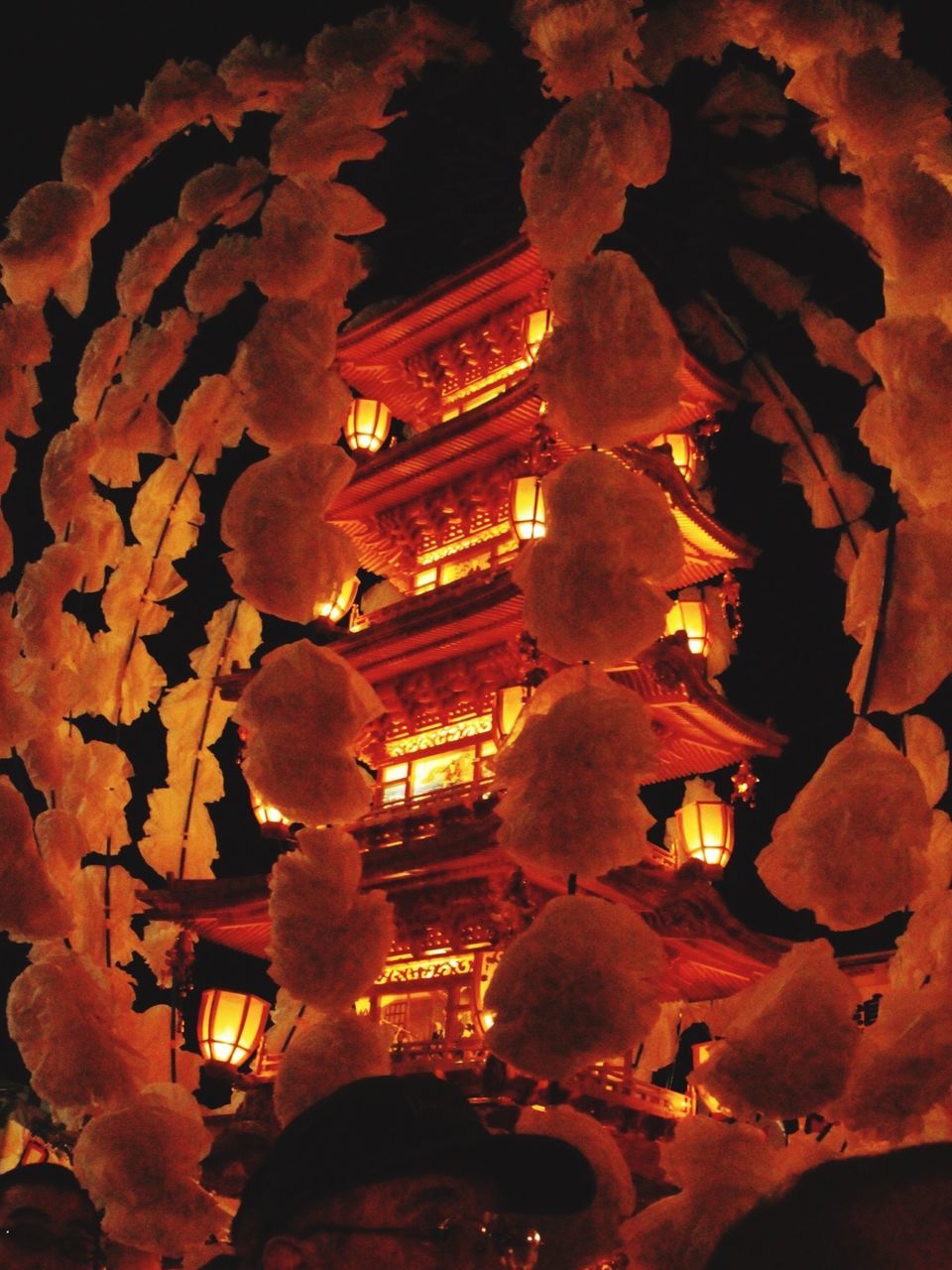 LOW ANGLE VIEW OF ILLUMINATED LANTERNS HANGING OUTSIDE TEMPLE AT CATHEDRAL