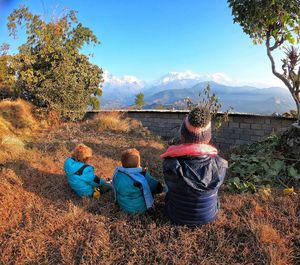 Rear view of family sitting on field