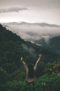 Rear view of man on mountain against sky