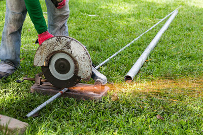 Low section of person working on grassy field