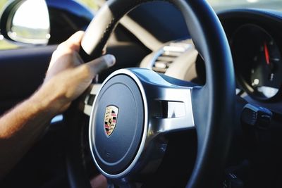 Close-up of hand on side-view mirror of car