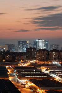 High angle view of illuminated cityscape against sky during sunset