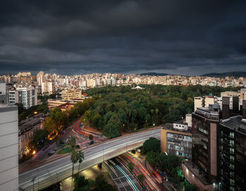 High angle view of illuminated buildings in city against sky at night