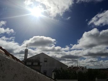 High section of buildings against blue sky on sunny day