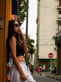 Portrait of young woman standing in city