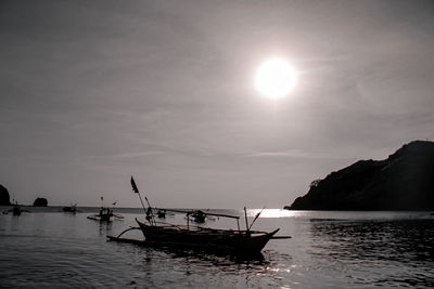 Silhouette of boat in sea against sky