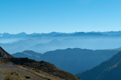 Scenic view of mountains against clear blue sky