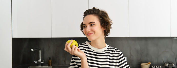 Side view of young woman using mobile phone while sitting on table