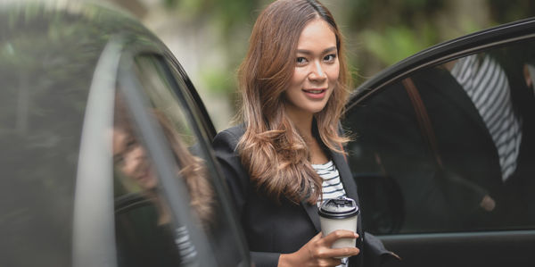 Portrait of smiling young woman in car