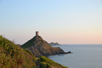 Scenic view of tower and sea against clear sky