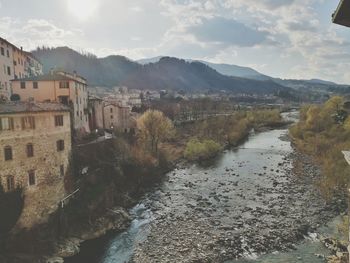 River amidst buildings in city against sky