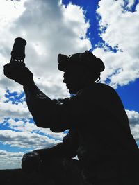 Low angle view of silhouette man standing against sky
