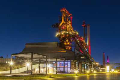 Low angle view of illuminated buildings against sky at night