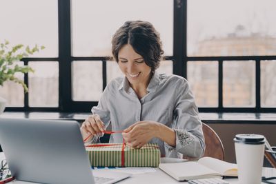 Businesswoman using laptop while sitting on table