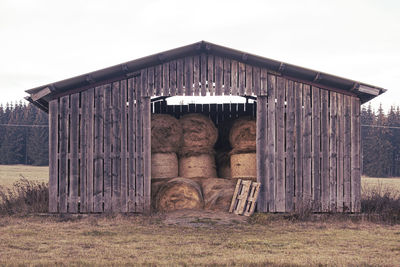 Barn on field against sky