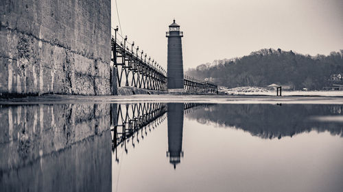 Reflection of lighthouse in puddle on pier