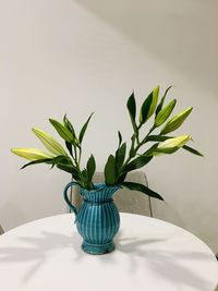 Close-up of vase on table against wall