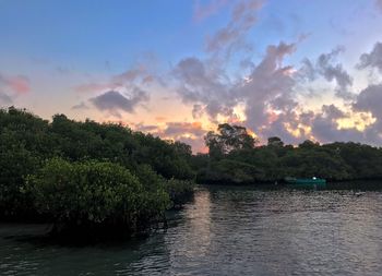 Scenic view of river against sky at sunset