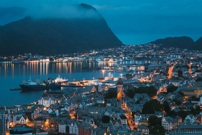 High angle view of illuminated cityscape against sky at night