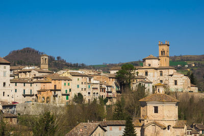 Buildings in town against clear blue sky