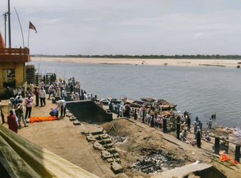 People by sea against sky