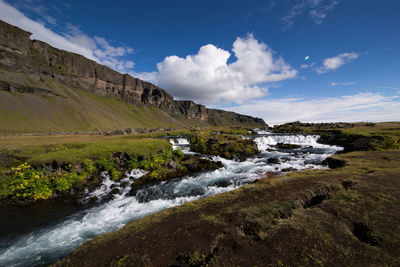 Scenic view of waterfall against sky