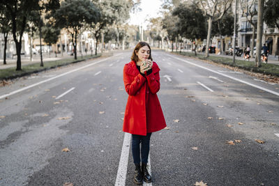 Full length portrait of woman standing on road