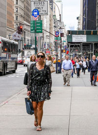 Full length of woman walking on city street