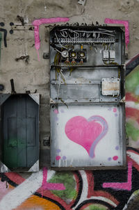 Graffiti on abandoned fuse box on wall