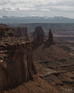 Rock formations on landscape against cloudy sky