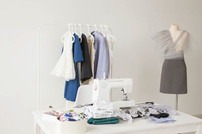 Clothes hanging on table against white wall