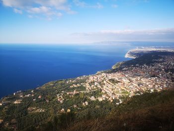 High angle view of townscape by sea against sky