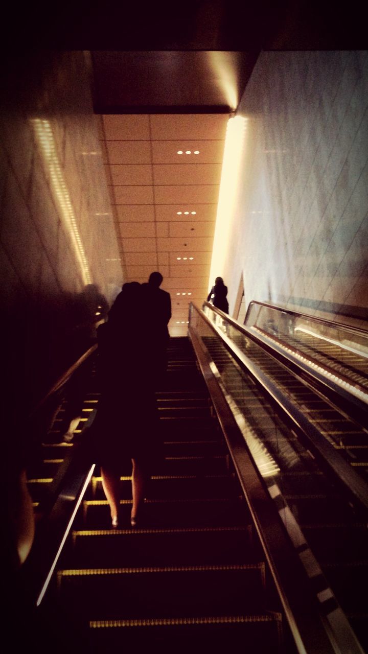 indoors, escalator, men, lifestyles, railroad track, transportation, rear view, rail transportation, railroad station, steps, subway, steps and staircases, public transportation, railroad station platform, full length, railing, person, walking