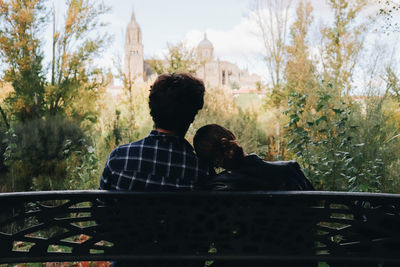 Side view of man sitting on railing