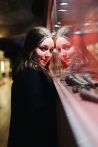 Portrait of young woman with reflection on glass