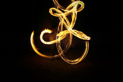 Close-up of illuminated lighting equipment against black background