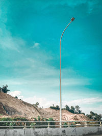 Street light by mountains against blue sky