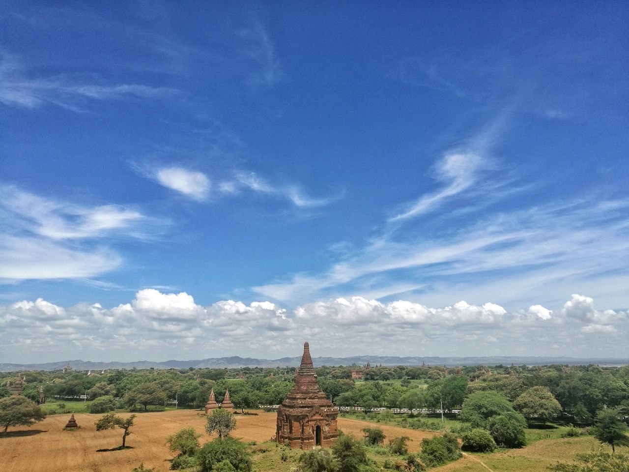 sky, landscape, blue, tranquility, tranquil scene, travel destinations, scenics, cloud - sky, nature, day, growth, outdoors, distant, tourism, beauty in nature, rural scene, place of worship, no people, agriculture, horizon over land, cultivated land, famous place, green color