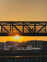 Illuminated bridge against sky during sunset