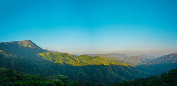 Scenic view of mountains against blue sky