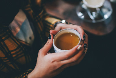 Midsection of woman holding coffee cup