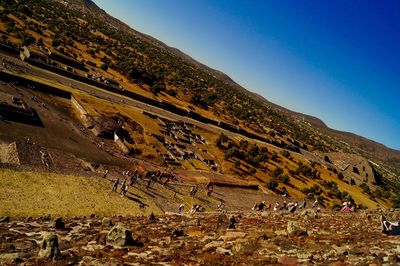 People on mountain against clear sky