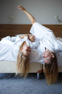 Happy woman lying down on bed